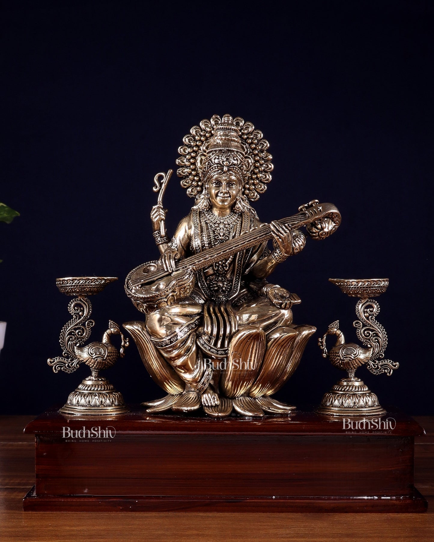 Brass Superfine Goddess Saraswati Idol with Twin Peacock Lamps on Wooden Base – 9.5 Inch - Sama Homes Idol - Brass Sculpture