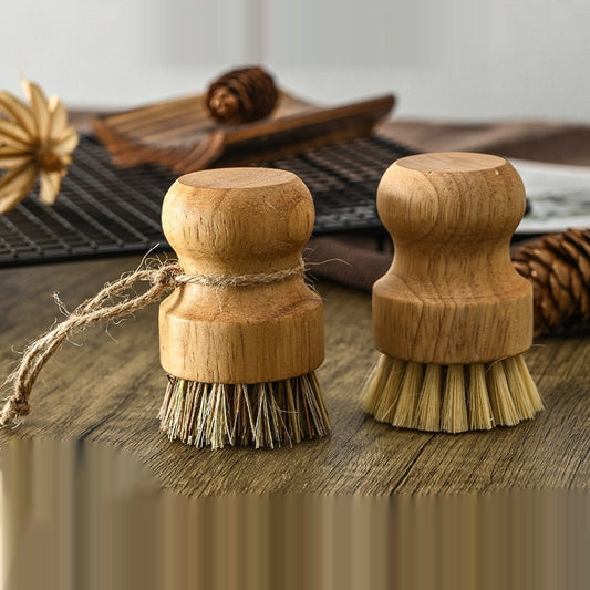 Two wooden dish brushes with natural bristles on a wooden surface.