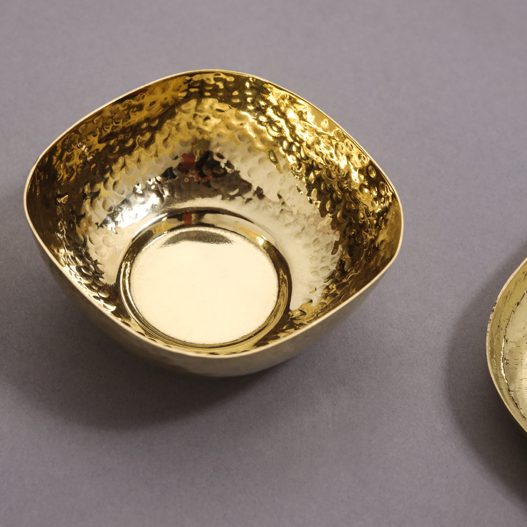 Gold bowl with textured surface on a gray background