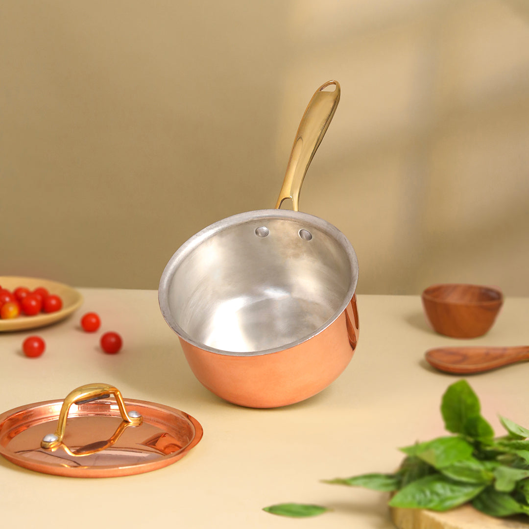 Copper saucepan with a lid on a table with vegetables and a wooden bowl. - Image 3