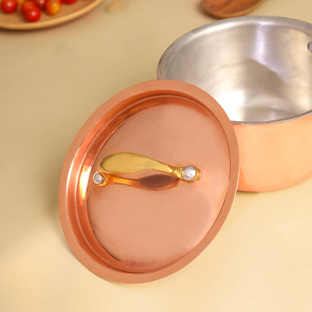 Copper pot lid with a gold handle on a beige surface - Image 6