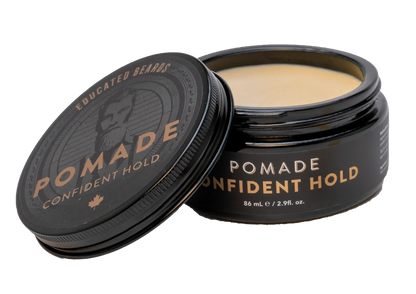 Pomade container with lid open showing product inside on a white background